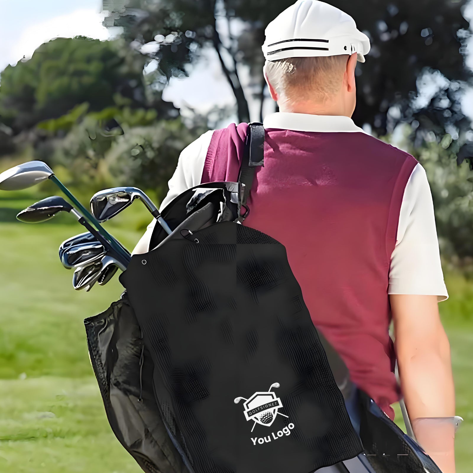 Golfer with a black bag containing golf clubs on a golf course