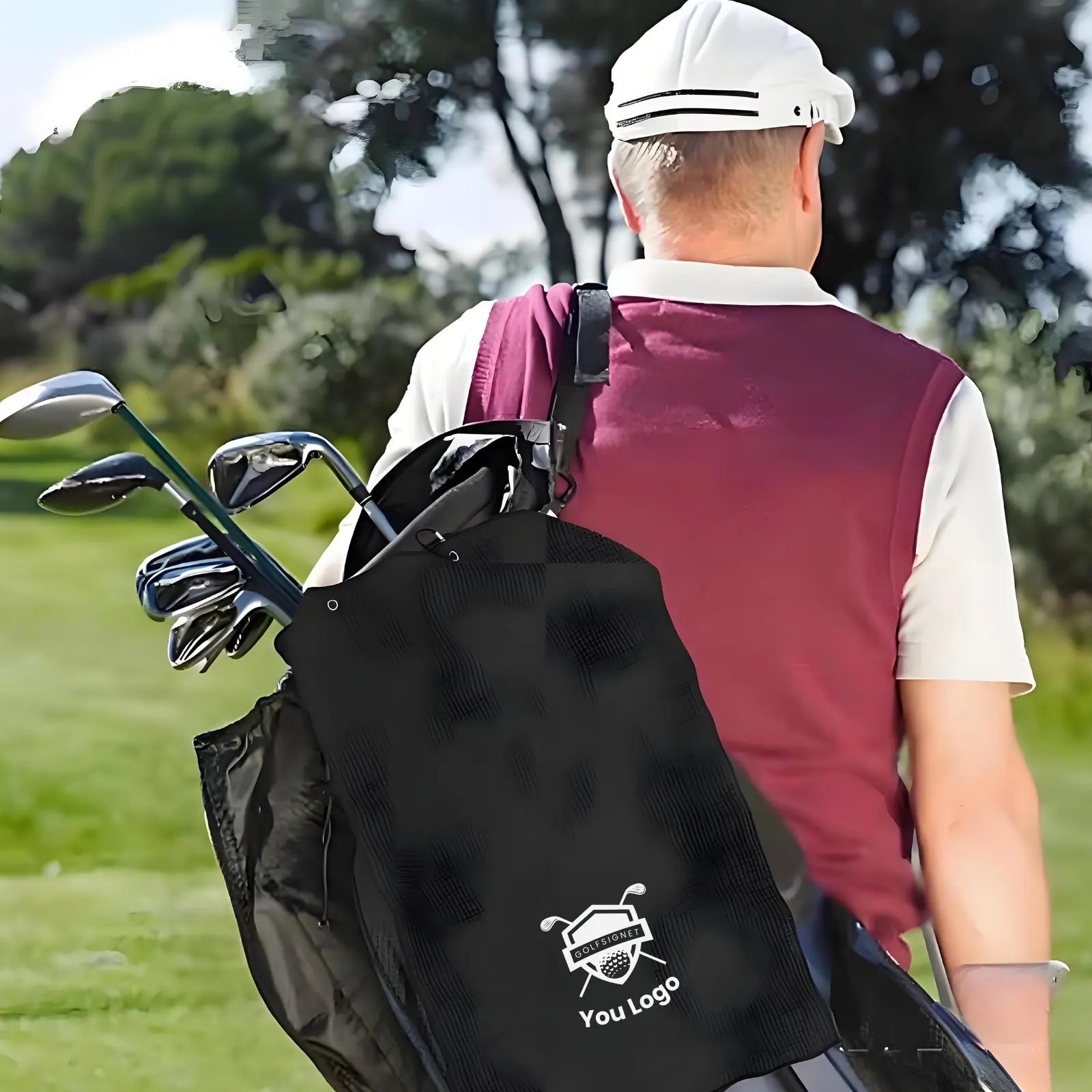 Golfer with a black bag containing golf clubs on a golf course