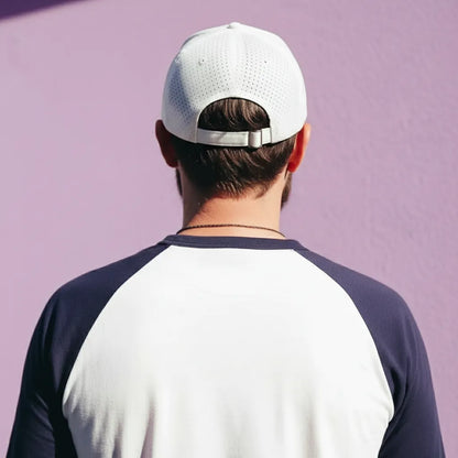 Person wearing a white cap and a two-tone shirt against a purple background